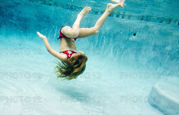Girl Floating Upside Down Underwater in Pool