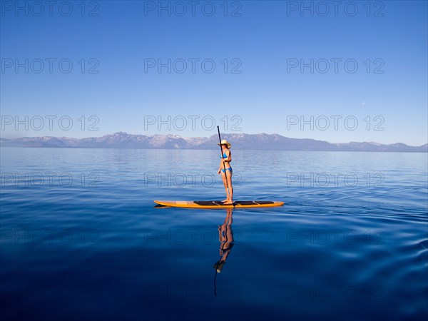 Woman Standing on Paddleboard Holding Paddle