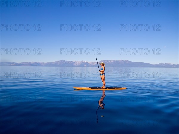 Woman Standing on Paddleboard Holding Paddle 2