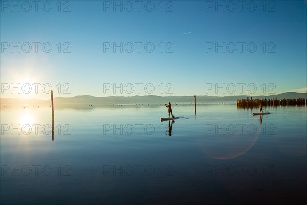 Mother and Daughter on Paddle Boards on Calm Water, Lake Tahoe, Nevada, USA
