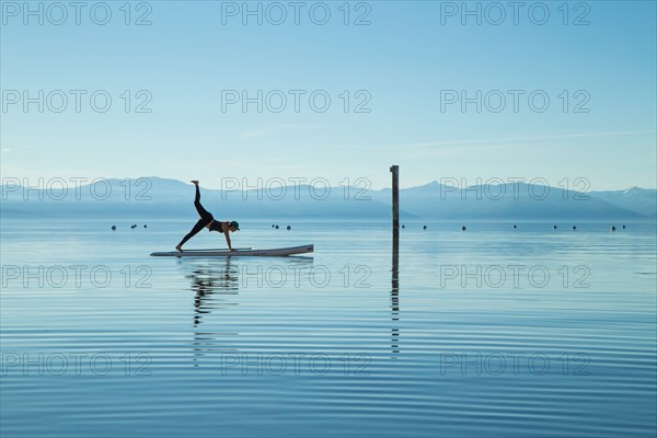 Woman in Yoga Pose on Paddle Board on Lake, Lake Tahoe, Nevada, USA