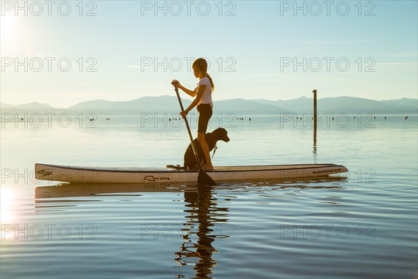 Young Girl and Dog on Paddle Board, Lake Tahoe, Nevada, USA