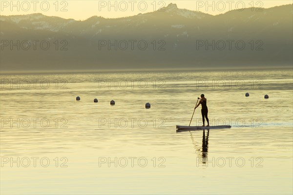 Woman on Paddle Board at Sunset, Lake Tahoe, Nevada, USA