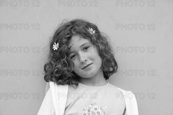 Smiling Young Girl with Two Flowers in Hair