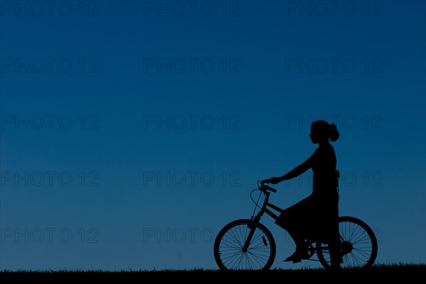Young Woman Riding Bicycle, Silhouette