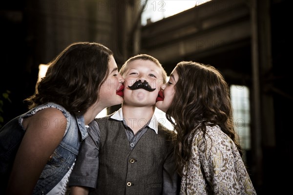 Two Girls Kissing Boy with Wax Lips in Abandoned Warehouse