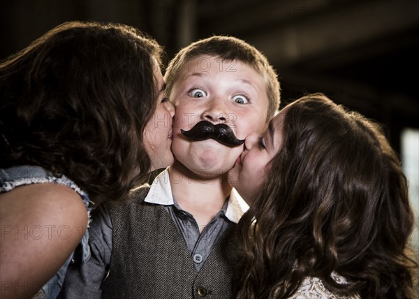 Two Girls Kissing Boy with Wax Lips in Abandoned Warehouse