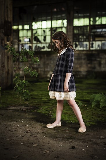 Young Girl Looking Down in Abandoned Warehouse, Portrait