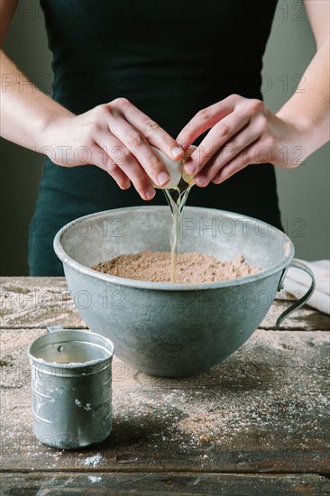 Egg Being Added to Cake Mix in Bowl