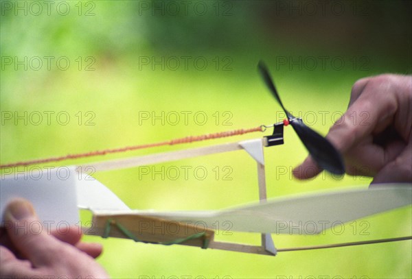 Man Winding Up Toy Airplane