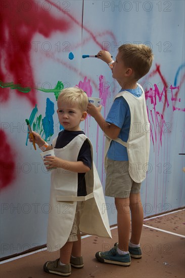 Two Young Boys Painting on Wall