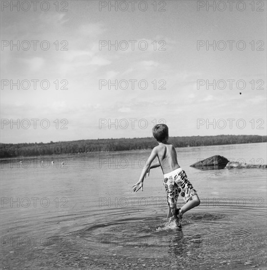 Young Boy Throwing Rock in Lake