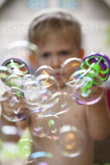 Young Boy Shooting Bubbles From Toy Gun