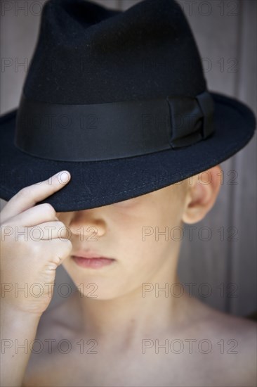 Young Boy Touching Brim of Fedora Hat