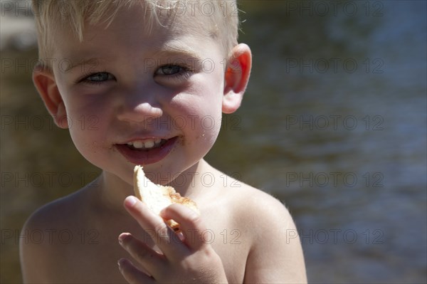 Smiling Boy Eating Bread