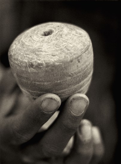 Hand Holding Toy Wooden Top, Close-Up