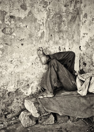 Man Laying on Stone Bench, New Delhi, India