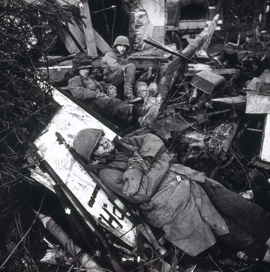 U.S. Soldiers Resting Among Ruins of Building, with Soldier Laying on Plank in Foreground, Siegfried Line, Rhoney Valley, German Front, Toni Frissell, Office of War Information, February 1945