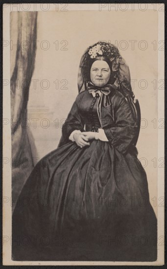Full-Length Seated Portrait Mary Todd Lincoln in Mourning Attire after the death of her son, Willie in 1862, Photograph by Joseph Ward, possibly 1863, when she entered a period of half-mourning by evidence of a touch of white fabric at her wrists