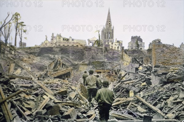 American Infantry Patrol Walking Through Ruins of the French Town, Saint-Lo, after it was Captured from the Germans, South Tower of Church of Notre Dame de Saint-Lo in Background, Battle of Normandy, Saint-Lo, France, July 1944