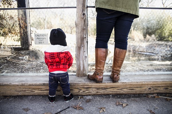 Rear View of Young Boy and Mother Standing Next to Each Other