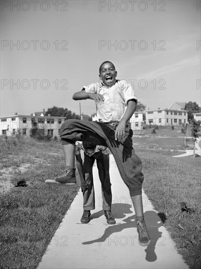 Two Boys Playing Leapfrog, Frederick Douglass Housing Project, Anacostia Neighborhood, Washington DC, USA, Photograph by Gordon Parks, July 1942