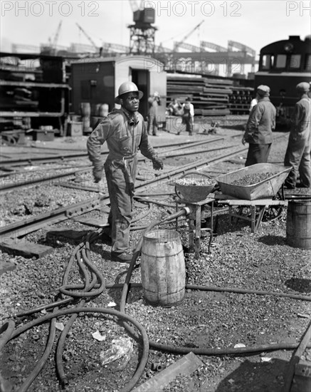 Rivet Heater engaged in Construction of Liberty Ship Frederick Douglass, Bethlehem-Fairfield Shipyards, Baltimore, Maryland, USA, Roger Smith, U.S. Office of War Information, May 1943