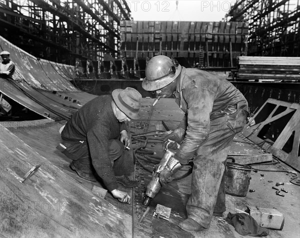 Tightening Bolts with Pneumatic Wrench during Construction of Liberty ship Frederick Douglass, Bethlehem-Fairfield Shipyards, Baltimore, Maryland, USA, Roger Smith, U.S. Office of War Information, May 1943