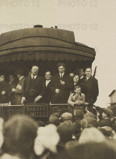 Theodore Roosevelt, with others, standing on back of Railroad car, speaking to crowd, Eugene, Oregon, USA, April 5, 1911