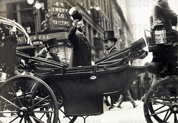 Theodore Roosevelt Standing in Carriage with his Hat Tipped while New York City Mayor William Gaynor and Cornelius Vanderbilt remain seated during his homecoming Reception after his trip abroad, New York City, New York, USA, June 1910