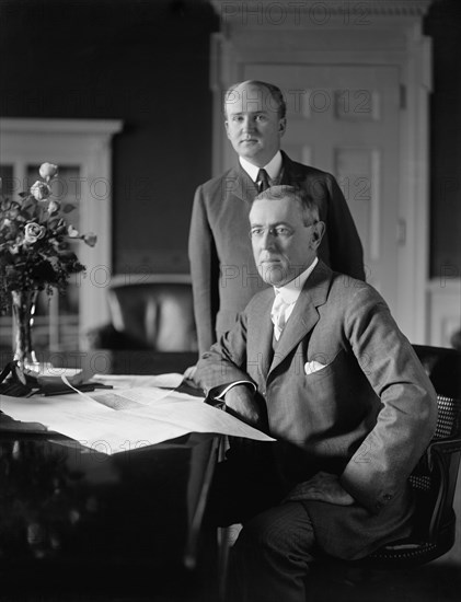 U.S. President Woodrow Wilson sitting at Desk in White House Oval Office with his Private Secretary Joseph Patrick Tumulty Standing nearby during Wilson's First Term in Office, Washington, D.C., USA, Harris & Ewing, between 1913 and 1916