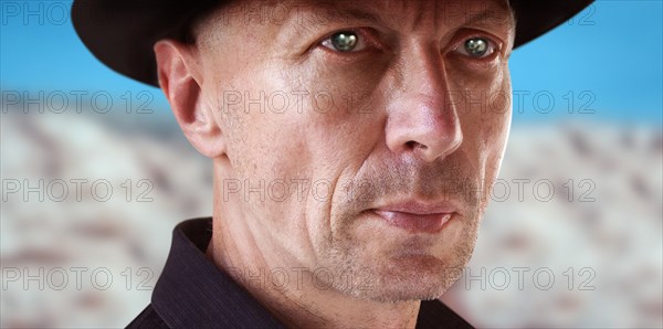 Close-up Portrait of Man in Cowboy Hat against Desert Background