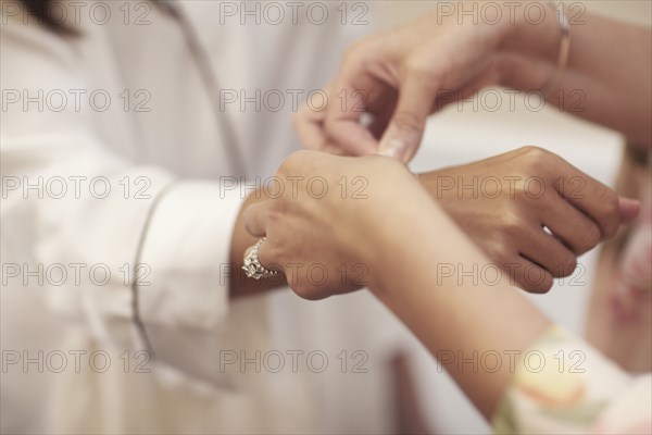 Putting Bracelet on Bride's Wrist, Selective Focus