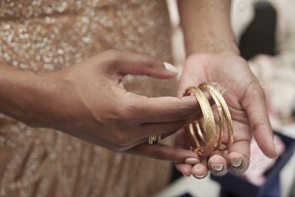 Woman Holding Gold Bracelets