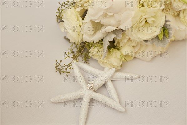 Engagement Ring on Starfish Decoration and Flowers