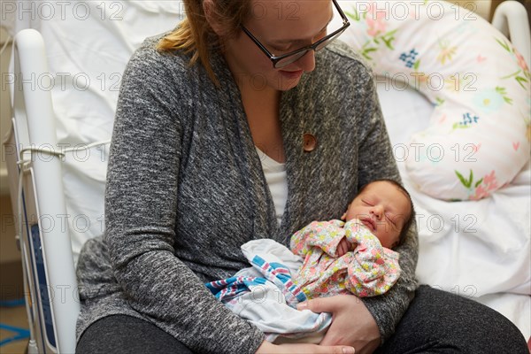 Newborn Baby Girl Being Held by Mother in Hospital