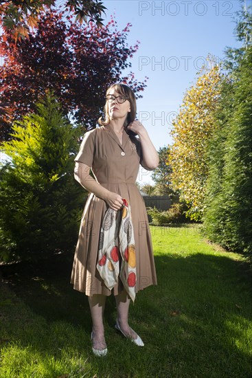 Full-Length Portrait of Mid-Adult Woman in Dress Holding Scarf Outdoor