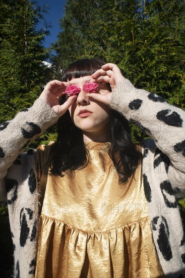 Half-Length Portrait of Young Adult Woman Holding Pink Roses to her Eyes