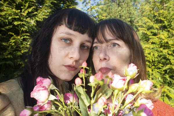 Head and Shoulders Portrait of Two Women, Heads Touching, with Bouquet of Flowers