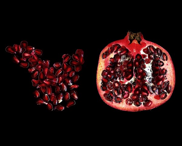 Sliced Pomegranate and Seeds on Black Background