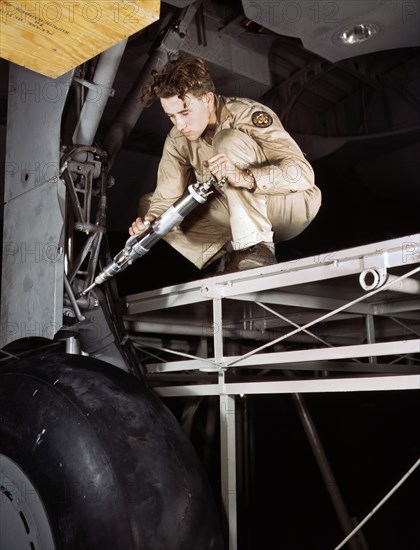 Hydraulic Mechanic greasing Landing Gear before Plane leaves Last Station on Assembly Line