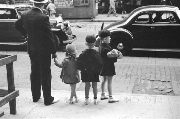 Father and three children waiting to cross the street