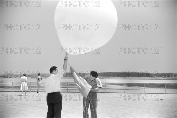 Two Men preparing to send up Weather Balloon at Weather Bureau at Airport