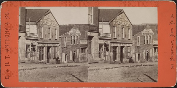 Man with Rifle sitting outside Commercial Building used as Slave Market