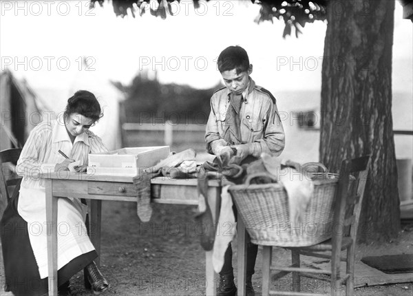 Boy Scout sorting Socks for Soldiers in Camp near Paris