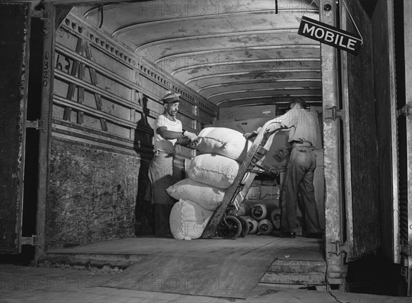 Two Workers loading Truck bound for Mobile