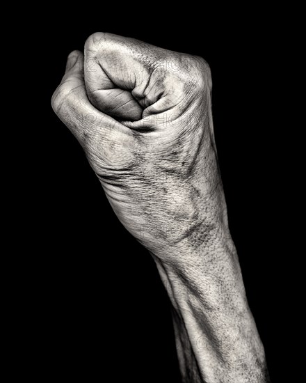 Mid-Adult Woman's Clenched Fist against Black Background