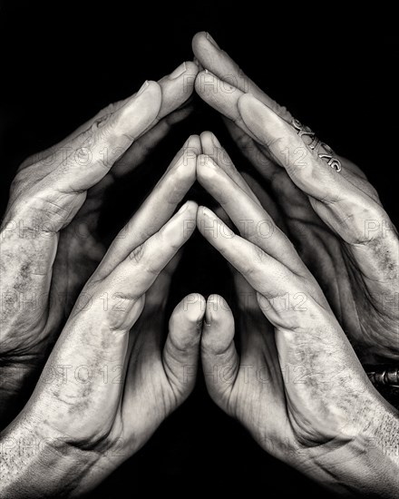 Close-Up of Two Pairs of Hands against Black Background