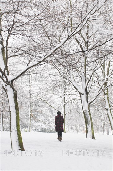 Rear View of Woman Walking in Snowy Landscape