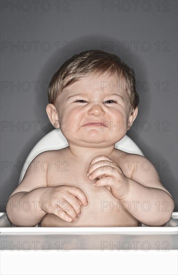 Unhappy Baby Boy in Highchair